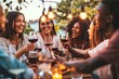 Multiracial friends celebrating rooftop party drinking red wine together - Cheerful young people enjoying barbeque diner in restaurant terrace - Happy, Generative AI