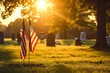 A solemn field of graves, adorned with fluttering flags and a solitary tree, basks in the warm sunlight on memorial day