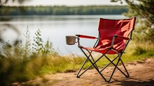 Red Camping Folding Chair With A Mug On The Background Of A Forest Lake. Generative AI