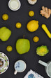 Colorful fruits, vegetables, kitchen tools, spices, oil on a dark kitchen table. Top view. 