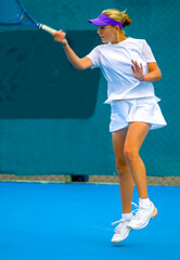 Wall Mural - A girl plays tennis on a court with a hard blue surface on a summer sunny day	