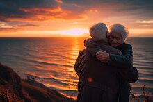 Elderly Duo Hugging, Watching Sunset Over Sea