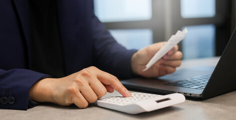 close up man hand press on calculator to check about debt bills pay monthly at the table in office a