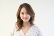 © Surachetsh - Serene young lady of Asian descent dons comfortable white loungewear, exuding a peaceful expression against a backdrop of pure white. Generative AI.
