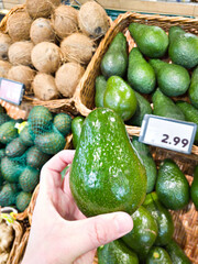 Wall Mural - Avocado in hand of buyer in shop