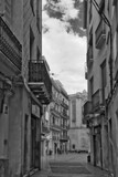 Fototapeta  - a street with a few buildings and a person walking down the street