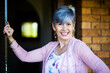 © Austockphoto - happy senior woman standing at her front door to welcome visitors