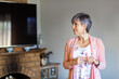 © Austockphoto - Oder woman looking to the side with copy space in her living room