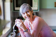 © Austockphoto - Portrait of a smiling senior woman with a cup of tea in the kitchen