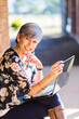 © Austockphoto - Portrait of a happy smiling middle aged woman working on her laptop outside