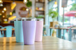 three pastel tumbler mockup, Coffee glass, stainless steel, reusable mixer blank, insulated aluminum cup, on blurred cafe background
