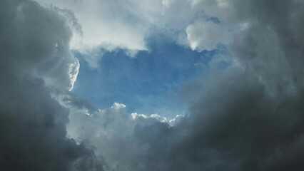 Wall Mural - Dark storm clouds moving and the hole with a piece of blue sky, timelapse 4k