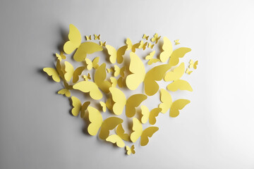 Canvas Print - Heart shape made of yellow paper butterflies on white background, top view