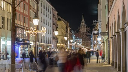 Poster - Historic buildings illuminated at the old town of Munich - sendlinger strasse night timelapse. Walking street with benches and streetlights. Glockenspiel on a background. Germany