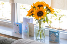 Close Up Of Sun Flowers In A Vase Over The Window With Birthday Cards 