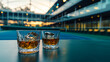 Cinematic wide angle photograph of two whisky glasses at a tennis stadium. Product photography.