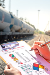 Wall Mural - action of an engineer is checking on chemical hazardous material checklist form with background of t