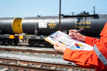 Wall Mural - action of an engineer is checking on chemical hazardous material checklist form with background of t
