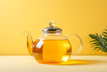 Transparent Glass Teapot With Tea On A Yellow And White Background