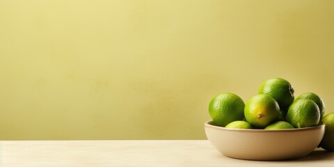 Wall Mural - Bowl of Fresh Green Limes on Table with Yellow Background. Generative AI