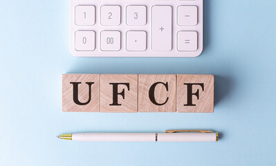 Wall Mural - UFCF UNVERED FREE CASH FLOW on wooden cubes with pen and calculator, financial concept