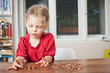 © MACO - Young girl counting pennies on the table.