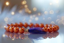Bracelet Made Of Orange Beads With A Purple Feather. A Place For The Text. 
