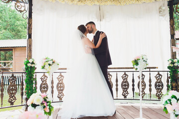 Wall Mural - groom and bride with a bouquet, posing in their wedding day. Enjoy a moment of happiness and love.