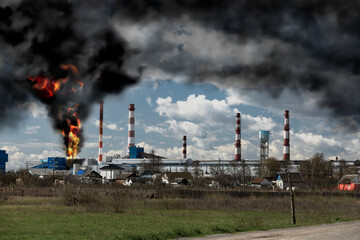 Fire and black smoke at the factory after the explosion. Black smoke rises high into the sky. Disaster concept