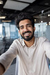 © Tetiana - Smiling indian businessman in casual shirt at modern office space