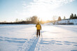 Skiing in the park on a frozen lake, glare of the sun against the background of a man running in the snow.