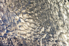 Golden Detail Of A Backlit Transparent Glacial Ice Fragment With Bubble Pattern In Icelnd