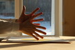Young man hands and contrasting sunlight on a window background. Photo was taken 22 January 2024 year, msk time.