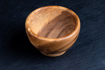 Wall Mural - an empty wooden bowl on a black slate table