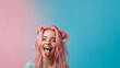 Hipster Girl in pink hair shows her tongue. smiling pretty girl sticking out tongue. Funny humorous young woman showing tongue at camera as if teasing someone, having playful look