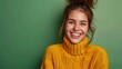 © Zahid - a happy, attractive girl with a toothy smile and good mood is wearing knitwear. Isolated on a green background