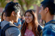 © Oliver Evans Studio - group of hispanic students talking smiling on a university campus happy friends one girl two boys sunlight outdoors friendship enjoying cheerful upbeat youth joy joyful authentic bonds
