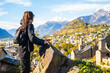Woman admiring the view of historical Sion town,spectacular set in the swiss Alps mountains valley, canton Valais, Switzerland