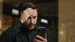 © Yuliia - Worried man Caucasian entrepreneur client in shopping mall has mobile phone problem failure trouble defeat upset stressed businessman lost job lose online business broken smartphone bad message debt
