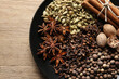 Different spices and nuts on wooden table, top view