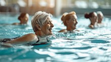 A Diverse Group Of Individuals Gather At An Indoor Leisure Centre To Partake In The Invigorating Sport Of Swimming, Their Faces Radiating With Joy As They Immerse Themselves In The Crystal-clear Wate