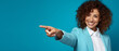 © Jess rodriguez - happy woman looking at a camera pointing finger on a blue background - copy space