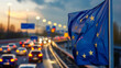 Vielbefahrene Straße mit Flagge der Europäischen Union (EU)  im Vordergrund.