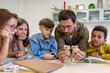 © zinkevych - Man teacher with kids during chemistry lesson in school classroom.