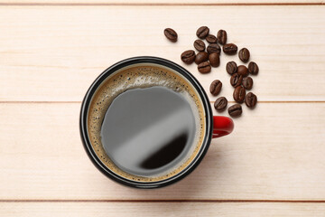 Canvas Print - Cup of aromatic coffee and beans on light wooden table, top view