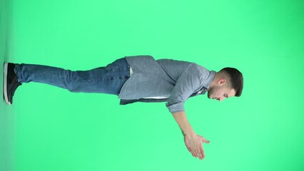 Wall Mural - A man, full-length, on a green background, spreads his arms