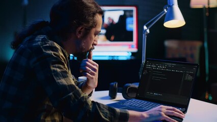 Poster - experienced programmer writes code on laptop screen while in apartment office using java programming