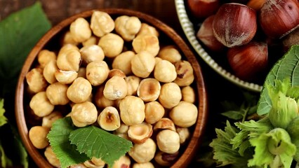 Wall Mural - shelled hazelnuts set in round plates.Healthy fats.View from above. Farmed organic ripe hazelnuts. 4k footage