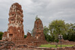 Red brick and stone ruin Buddhist Thai temple pagoda structures of Wat Chaiwatthanaram historical park in Ayutthaya Thailand on a cloudy day