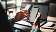 © ZeNDaY - Close-up of a professional's hands using a smartphone in front of an open laptop.